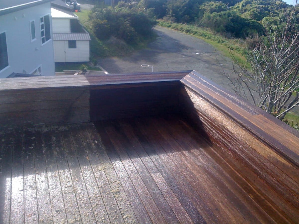 Karori deck restoration in Wellington, dark-stained timber deck with matching balustrade overlooking a suburban Karori street, fresh stain catching the morning light (suburb from EXIF GPS)