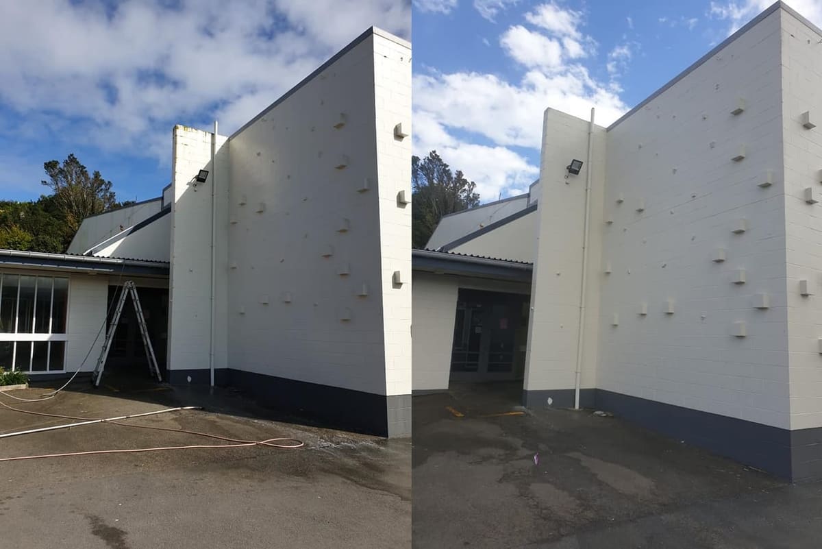Wellington school exterior cleaning at Newlands College, large painted block gable wall softwashed and biocide treated, lifting dirt streaks and yellow staining from the white render.