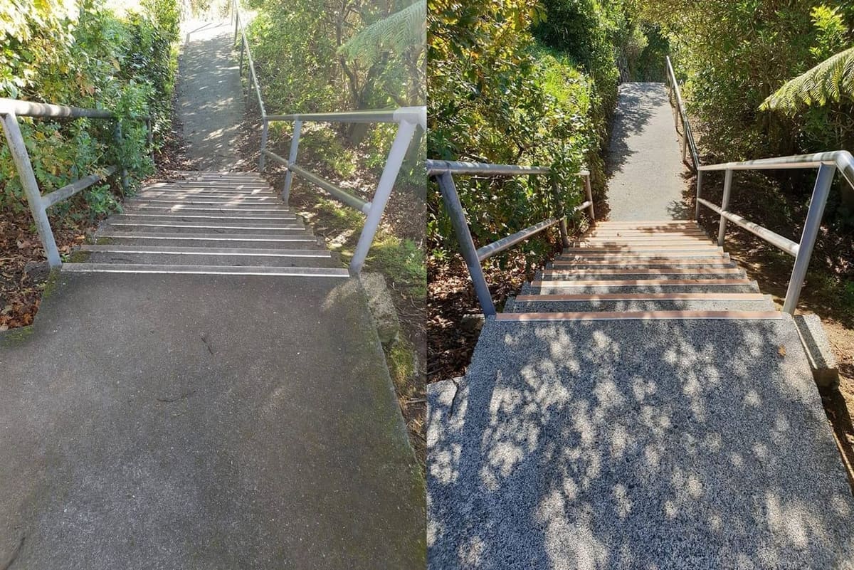 Wellington school path cleaning at Newlands College, concrete stairs running down a grass embankment to the lower field softwashed, restoring a uniform pale tread surface for student traffic.