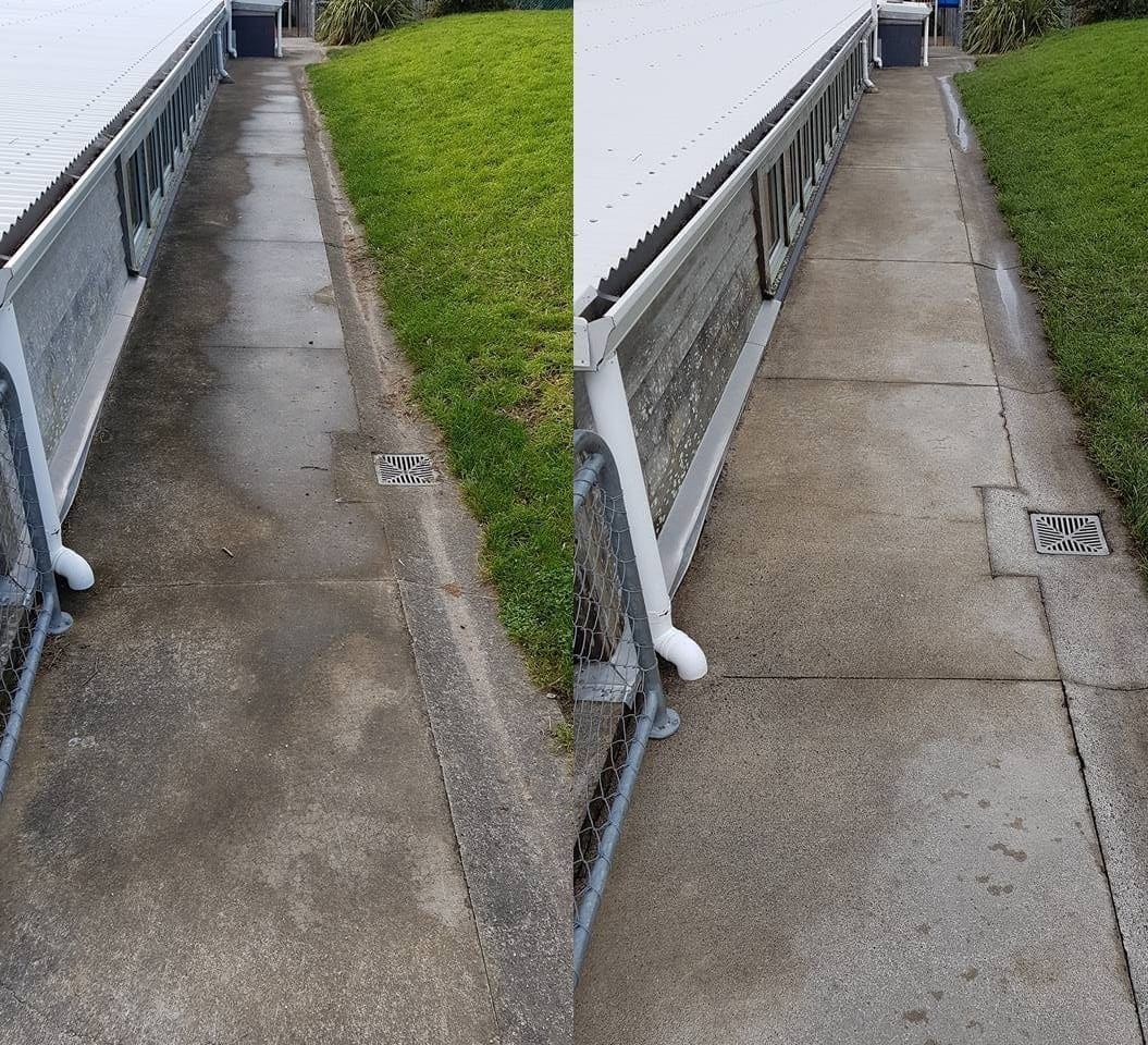 Wellington school path cleaning at Worser Bay School, classroom side walkway with heavy lichen growth softwashed and rinsed, restoring grip and visibility along the channel drain.