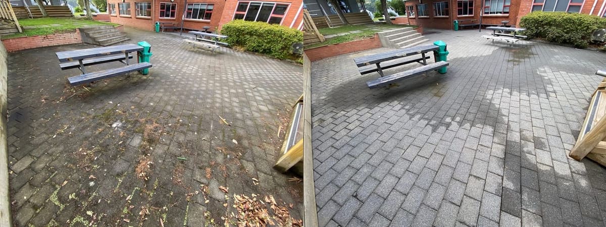Wellington school path cleaning at Wellington High School, paved courtyard with picnic tables stripped of leaf litter, moss seams and grime, returning crisp grey pavers and clean grout lines.